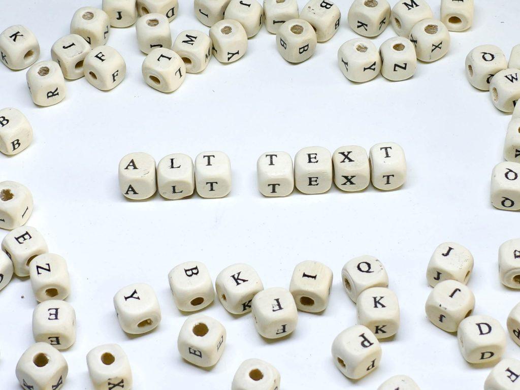 Beads spelling 'ALT TEXT' amid scattered letters, highlighting digital accessibility