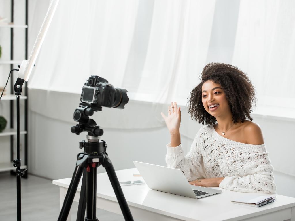 Woman recording a video with camera and laptop, representing how influencer marketing can boost your landscaping SEO